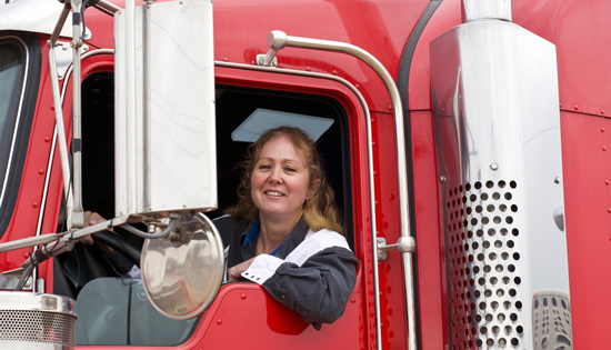 Woman sitting in the cab of a semi truck