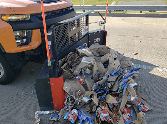 truck plow cleaning up garbage from road