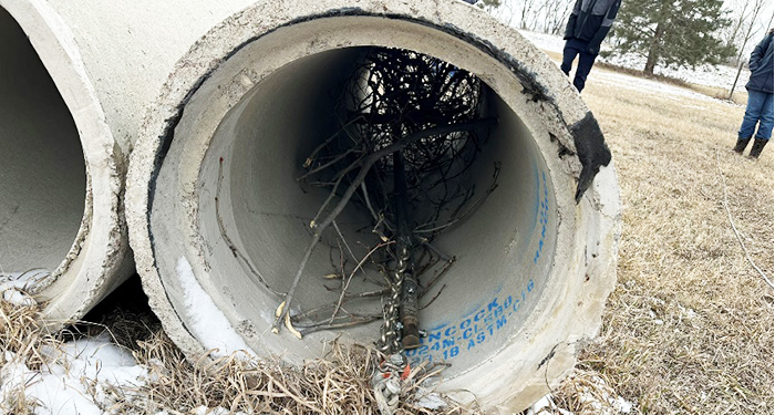 A grapple hook cleans out a culvert pipe.