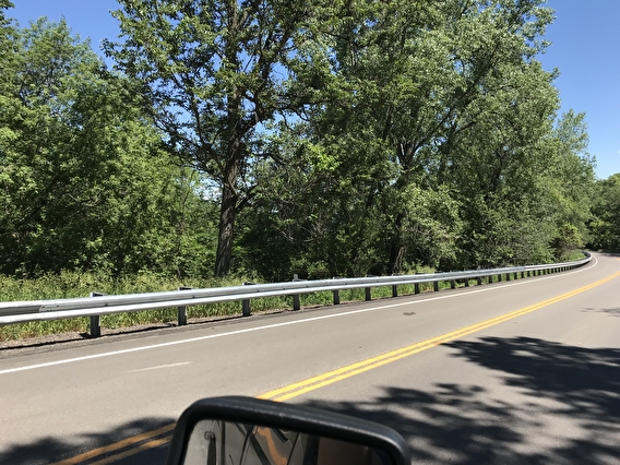 A guardrail on the side of a paved road.