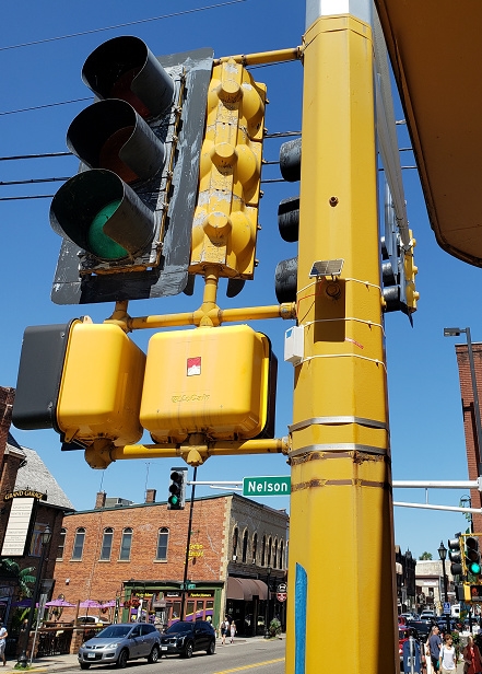 A stoplight sits on a pole above a street.