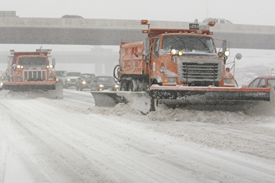 snowplow on a highway in a snowstorm