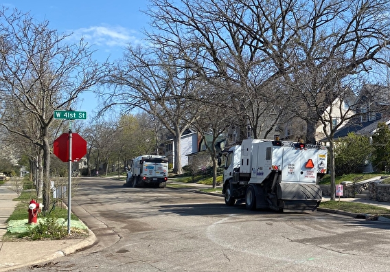 Two street sweepers on a neighborhood street