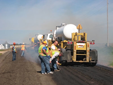 Blue Earth County workers performing gravel road stabilization 