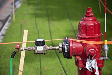Temporary roadside turf irrigation system connected to a fire hydrant