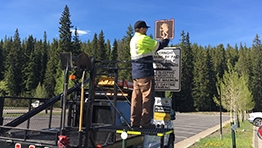 maintenance worker on truck fixing a road sign