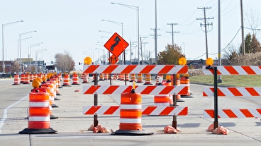 Orange barrels and barricades marking a roadway work zone